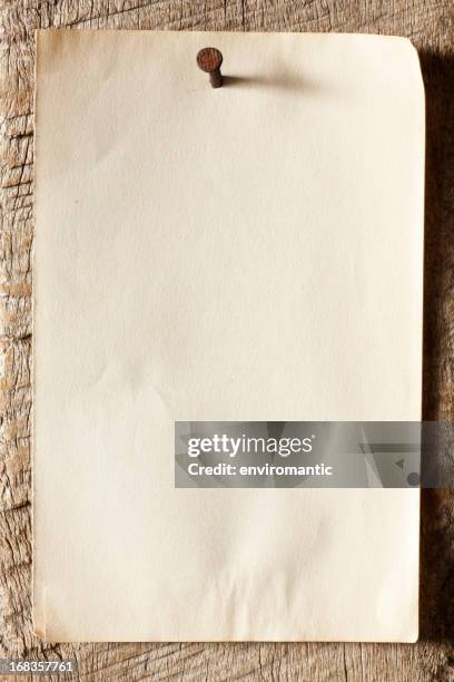 old paper nailed to a weathered wooden board. - pinning stock pictures, royalty-free photos & images