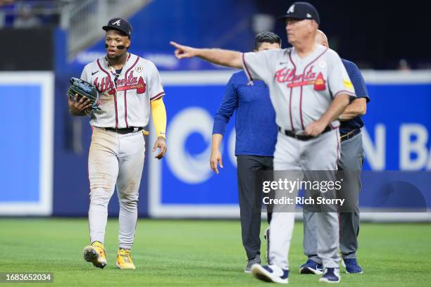 Ronald Acuna Jr. #13 of the Atlanta Braves leaves the field with manager Brian Snitker and staff after a apparent injury against the Miami Marlins...