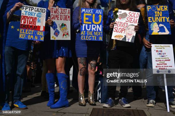 Protesters hold anti-Brexit placards calling for the UK to rejoin the EU during a march from Hyde Park to Palace of Westminster in central London on...