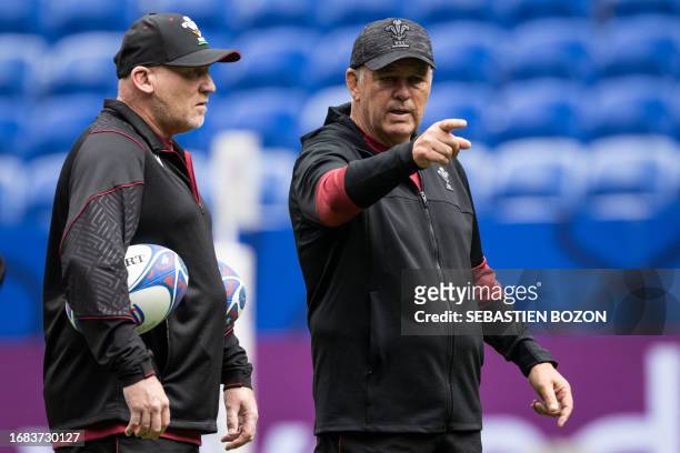 Wales' head coach Warren Gatland speaks with Wale's assistant coach Neil Jenkins during the captain's run training session at OL Stadium in...