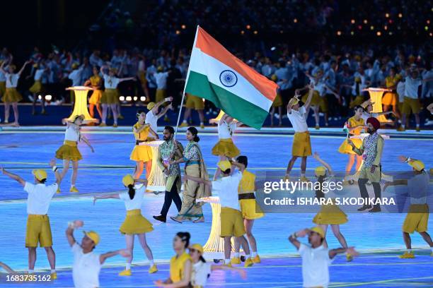 Members of India's delegation take part in the athletes parade during the opening ceremony of the 2022 Asian Games at the Hangzhou Olympic Sports...