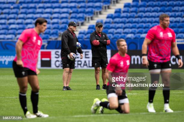 Wales' head coach Warren Gatland speaks with Wales' assistant coach Neil Jenkins during the captain's run training session at OL Stadium in...