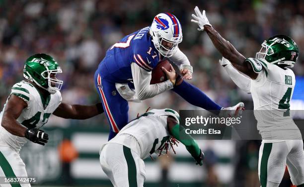 Josh Allen of the Buffalo Bills tries to leap over C.J. Mosley of the New York Jets as Bryce Huff and D.J. Reed of the New York Jets defend at...