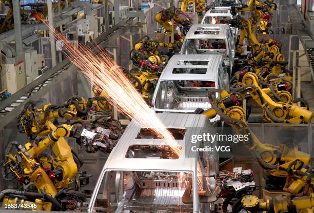 Automated robotic arms work on the assembly line of Voyah electric vehicles at Dongfeng Motor's Voyah Automobile factory on August 23, 2023 in Wuhan,...