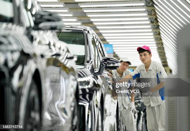 Employees work on the assembly line of Voyah electric vehicles at Dongfeng Motor's Voyah Automobile factory on August 23, 2023 in Wuhan, Hubei...