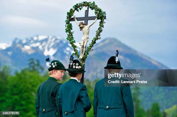 Three boys wearing Bavarian folk costumes specific to the Chiemsee region of southern Bavaria carry a cross during the annual Ascension Day...