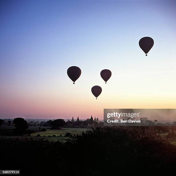 At sunrise four hot air balloons fly over the ancient temples of Bagan as viewed from the Shwesandaw Temple. In all, there are more than 2,000...