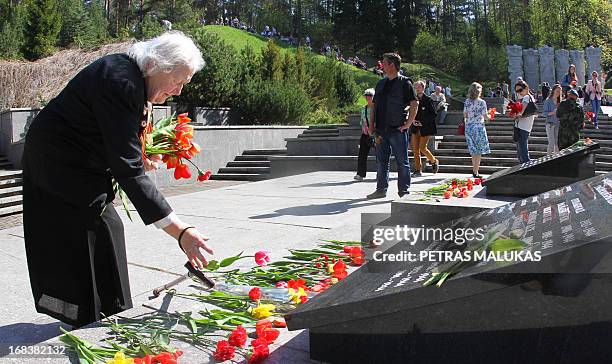 Ana Kuskina , a 84-year-old veteran of World War II, lays down flowers on May 9, 2013 at the tomb of the Unknown Soldier at the Antakalnis memorial...