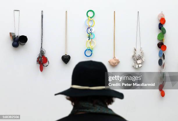 Visitor looks at jewellery on display at the Collect art fair at Saatchi Gallery on May 9, 2013 in London, England. Celebrating its 10th anniversary...