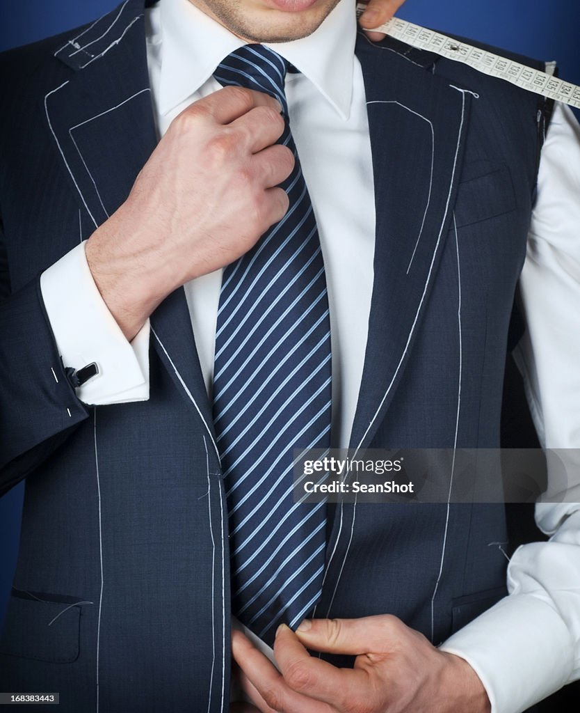 Homme vêtu d'un manteau noir, blanc et bleu ensemble à rayures cravate.