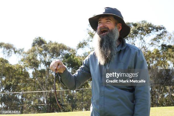 Snake catcher picks up a snake on the sideline during the round three AFLW match between Greater Western Sydney Giants and Richmond Tigers at...