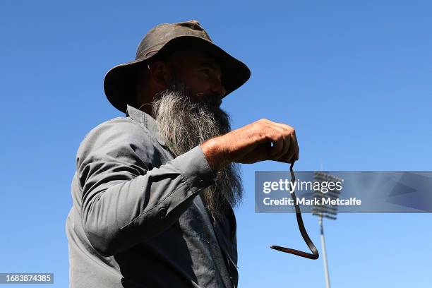 Snake catcher picks up a snake on the sideline during the round three AFLW match between Greater Western Sydney Giants and Richmond Tigers at...