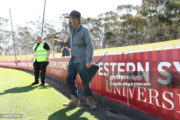 Snake catcher picks up a snake on the sideline during the round three AFLW match between Greater Western Sydney Giants and Richmond Tigers at...