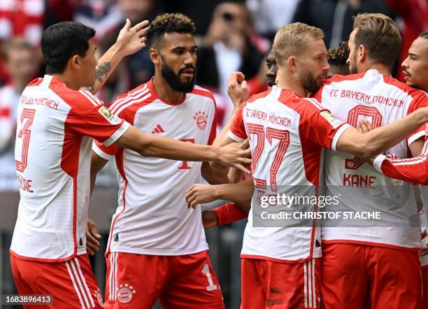 Bayern Munich's Cameroonian forward Eric Maxim Choupo-Moting is congratulated by teammates after scoring the 1-0 goal during the German first...