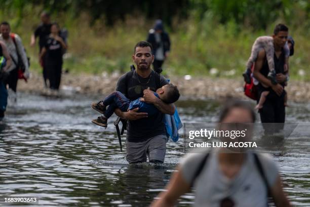 Migrants cross the Tuquesa river near Bajo Chiquito village, the first border control of the Darien Province in Panama, on September 22, 2023. The...