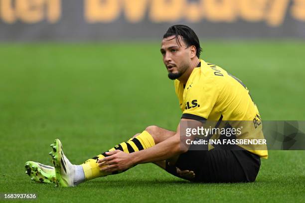 Dortmund's Algerian defender Ramy Bensebaini reacts on the ground during the German first division Bundesliga football match between Borussia...