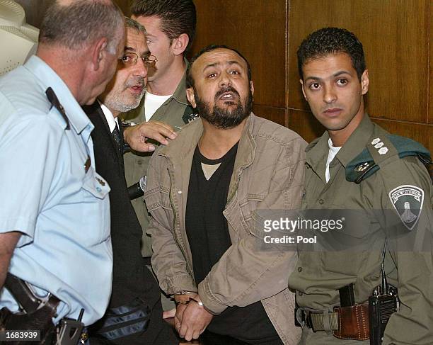 Marwan Barghuti shouts back to a Jewish man accusing him of the murder of "our children," next to his lawyer Jawal Boulus, at the district court...