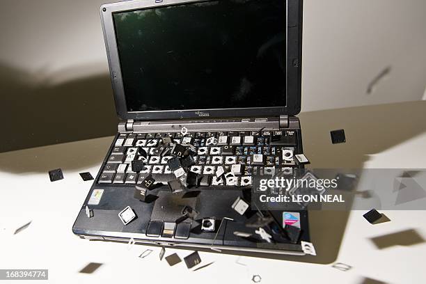 This picture taken in London on May 9, 2013 is a posed image of a laptop computer's keyboard shattering into pieces after an impact. AFP PHOTO/Leon...