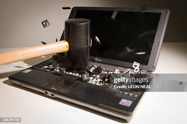 This picture taken in London on May 9, 2013 is a posed image of a laptop computer's keyboard shattering into pieces after an impact. AFP PHOTO/Leon...