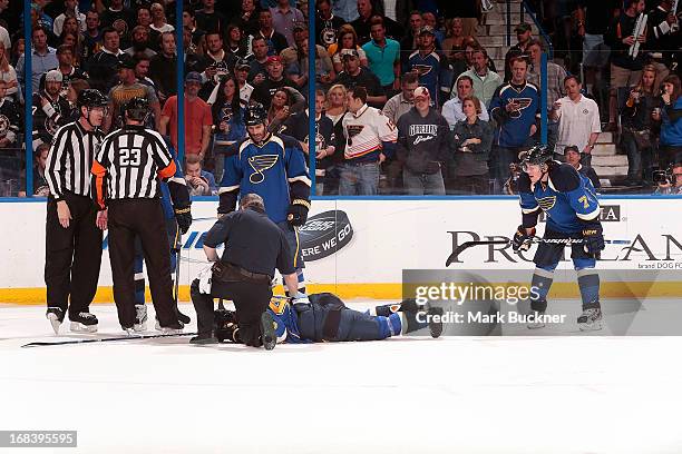 Roman Polak of the St. Louis Blues lays on the ice as trainerRay Barile looks over him after being injured while playing the Los Angeles Kings in...