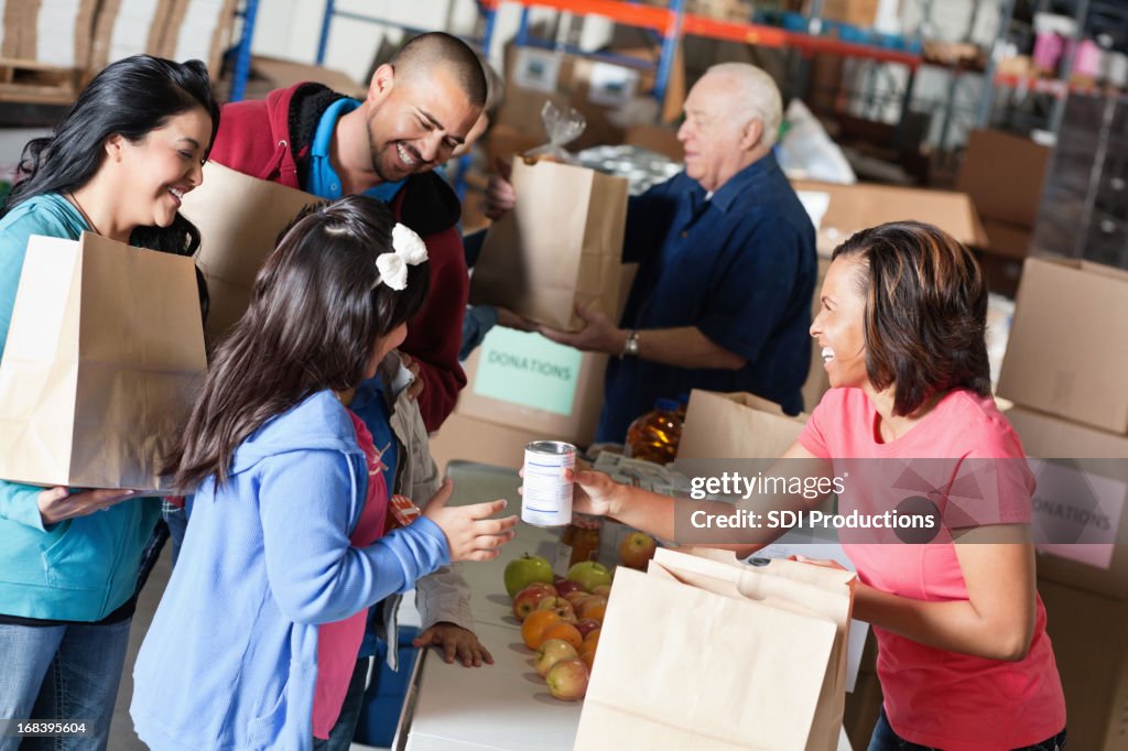 Freiwillige akzeptieren Spenden von Familie im food bank