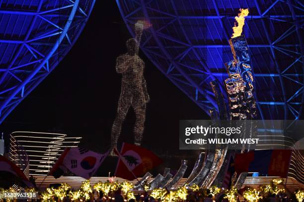 The Asian Games flame is lit in the cauldron during the opening ceremony of the 2022 Asian Games at the Hangzhou Olympic Sports Centre Stadium in...