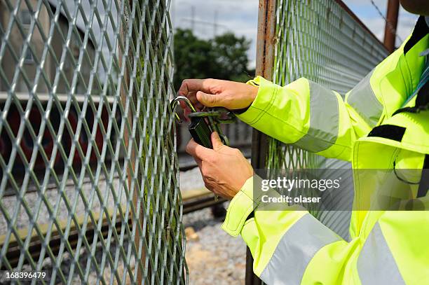 man opening padlock - chain fence stock pictures, royalty-free photos & images