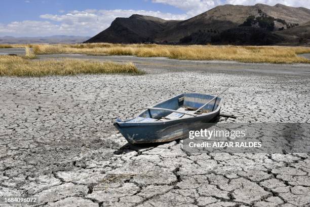 Boat is grounded on cracked earth in the Bahia Cohana area of Lake Titicaca, shared by Bolivia and Peru, in the Bolivian Altiplano on September 22,...