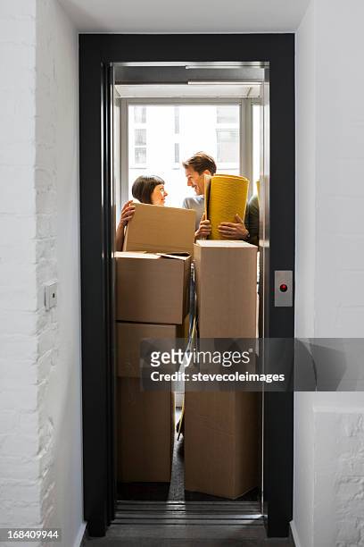 moving couple - crowded elevator stockfoto's en -beelden