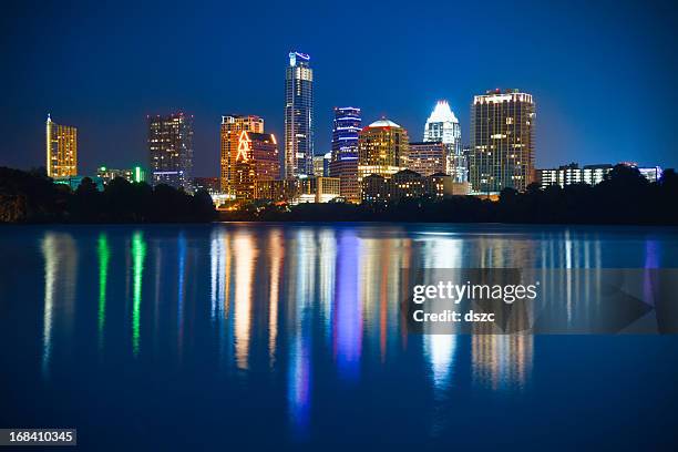 vista de los edificios de la ciudad por la noche, austin refleja en el lago de mariquita - austin texas fotografías e imágenes de stock