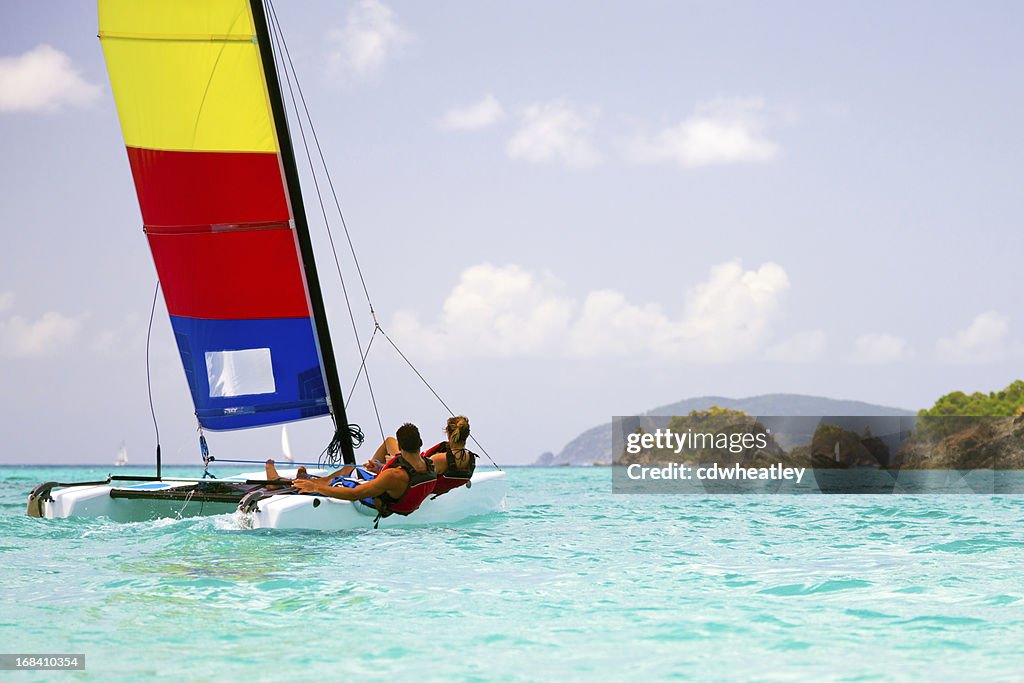 Couple sailing a catamaran in the Virgin Islands