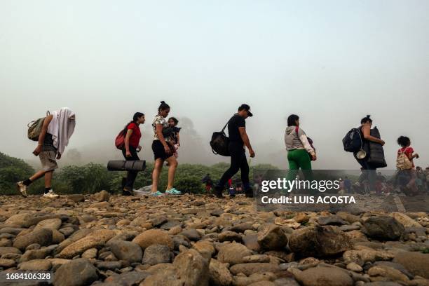 Migrants walk by the jungle near Bajo Chiquito village, the first border control of the Darien Province in Panama, on September 22, 2023. The...