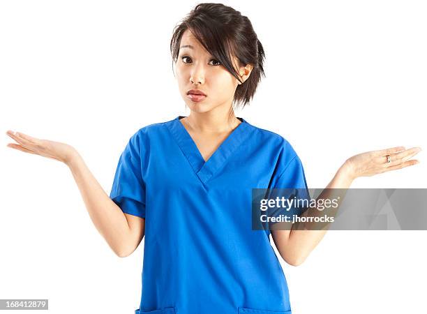 junge asiatische krankenschwester in blauer peelings achselzucken - confused white background stock-fotos und bilder
