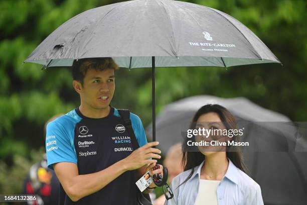 Alexander Albon of Thailand and Williams and Lily Muni He walk in the Paddock prior to final practice ahead of the F1 Grand Prix of Singapore at...