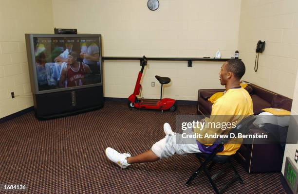 Guard Kobe Bryant of the Los Angeles Lakers watches the NBA game on television between the Atlanta Hawks and Boston Celtics from the training room...