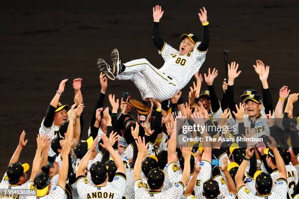 Head coach Akinobu Okada of the Hanshin Tigers is tossed into the air as the team celebrates the Central League season champions following the game...