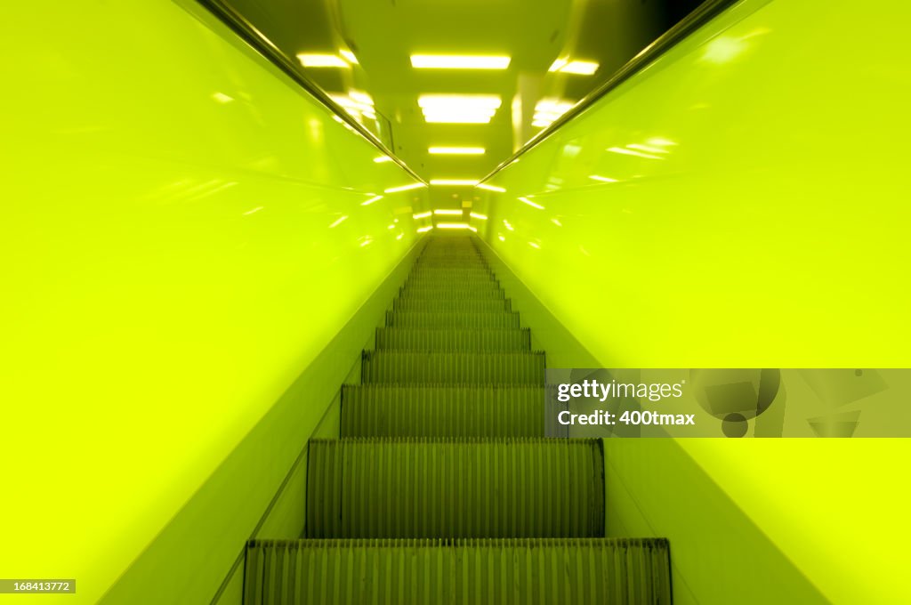 Green neon lit moving escalator
