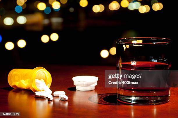 whisky or rum and a bottle of spilled pills - cirrhosis 個照片及圖片檔