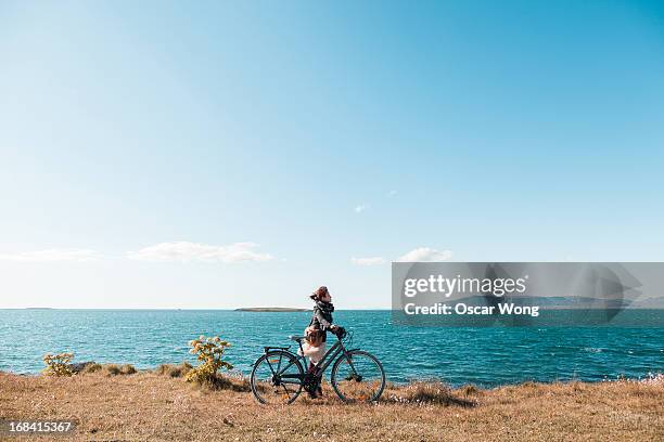 riding bicycle by the sea - reykjavik stock pictures, royalty-free photos & images