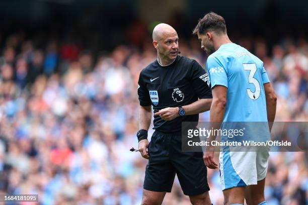 Referee Anthony Taylor speaks with Ruben Dias of Manchester City during the Premier League match between Manchester City and Nottingham Forest at...