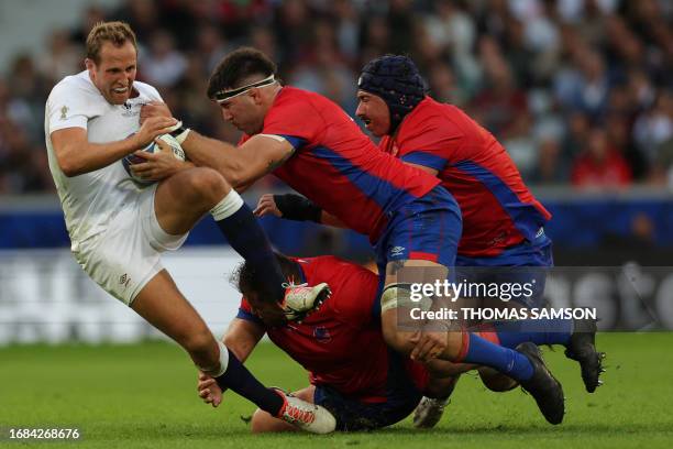 England's wing Max Malins is tackled by Chile's lock Clemente Saavedra and Chile's lock Javier Eissmann during the France 2023 Rugby World Cup Pool D...