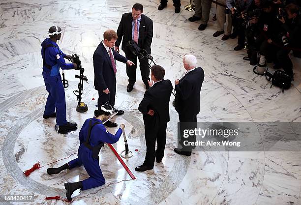 Prince Harry talks to mine detection demonstrators as he tours the HALO Trust exhibit on landmines and unexploded ordnances inside the Rotunda of...