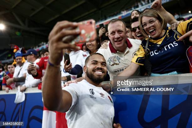 England's inside centre Ollie Lawrence poses for a 'selfie' with supporters after the France 2023 Rugby World Cup Pool D match between England and...