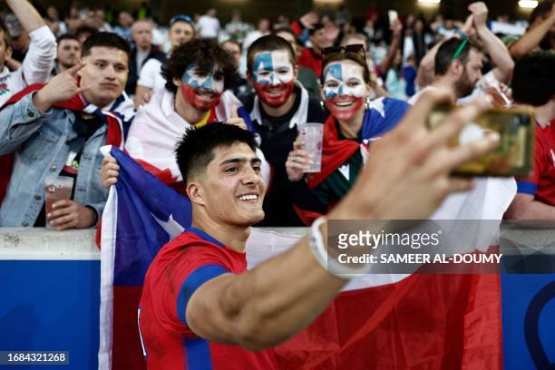 Chile's wing Cristobal Game poses for a 'selfie' with supporters after the France 2023 Rugby World Cup Pool D match between England and Chile at...