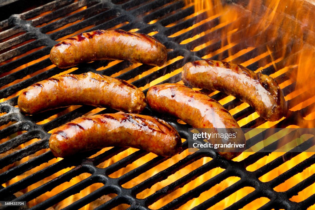 Bratwurst und Hot Dogs auf dem Grill mit Flammen