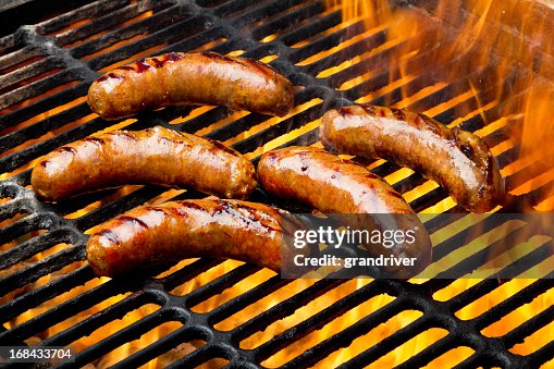 Bratwurst or Hot Dogs on Grill with Flames Bratwurst or Hot Dogs on Grill with Flames