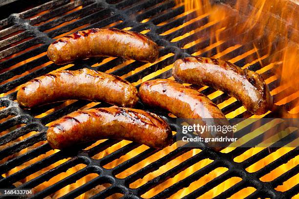 bratwurst or hot dogs on grill with flames - fried bildbanksfoton och bilder