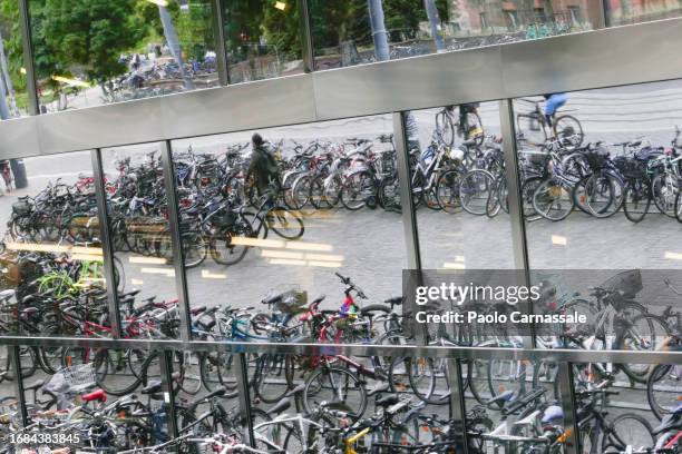 large group of bycicles parked  in front  of glass facade and their reflection - freiburg skyline stock pictures, royalty-free photos & images