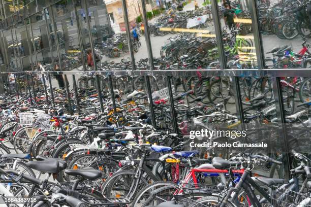 many bycicles parked and reflected in front of glass window facade - freiburg skyline stock pictures, royalty-free photos & images