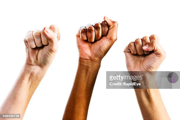 tres clenched hembra fists triumphantly apoyando los derechos de la mujer - clenched fist fotografías e imágenes de stock